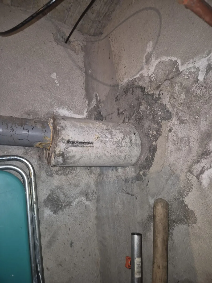Geschilderde cementgebonden buis in een kelderruimte