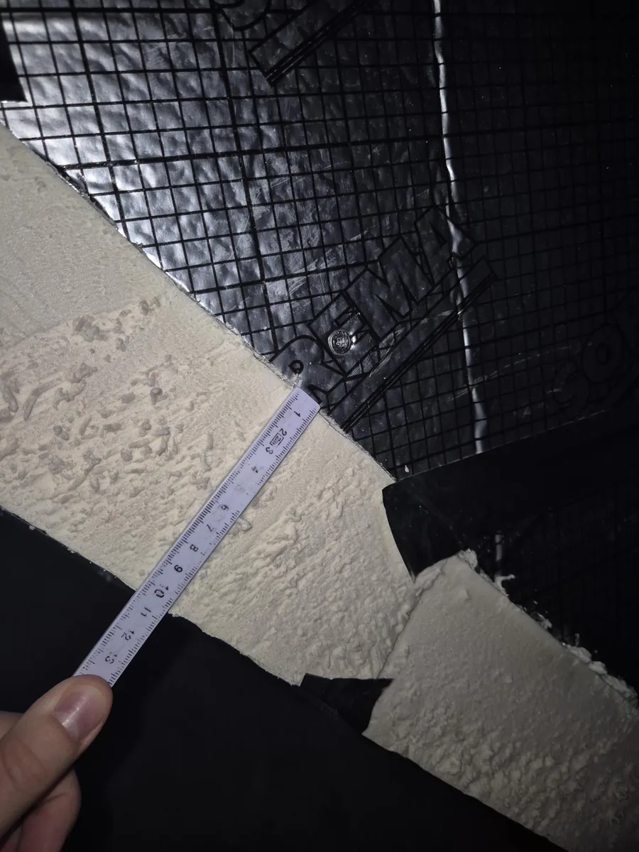 Detailfoto van isolatiemateriaal waarvan de dikte met een vouwmeter wordt gemeten